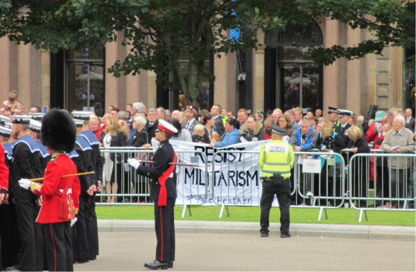 Photo: Resist Militarism Network unfurl a banner 'Resist Militarism #whitefeather' as Prince Charles arrives in George Square during the WW1 Centenary Ceremony on 4th Aug 2014] 