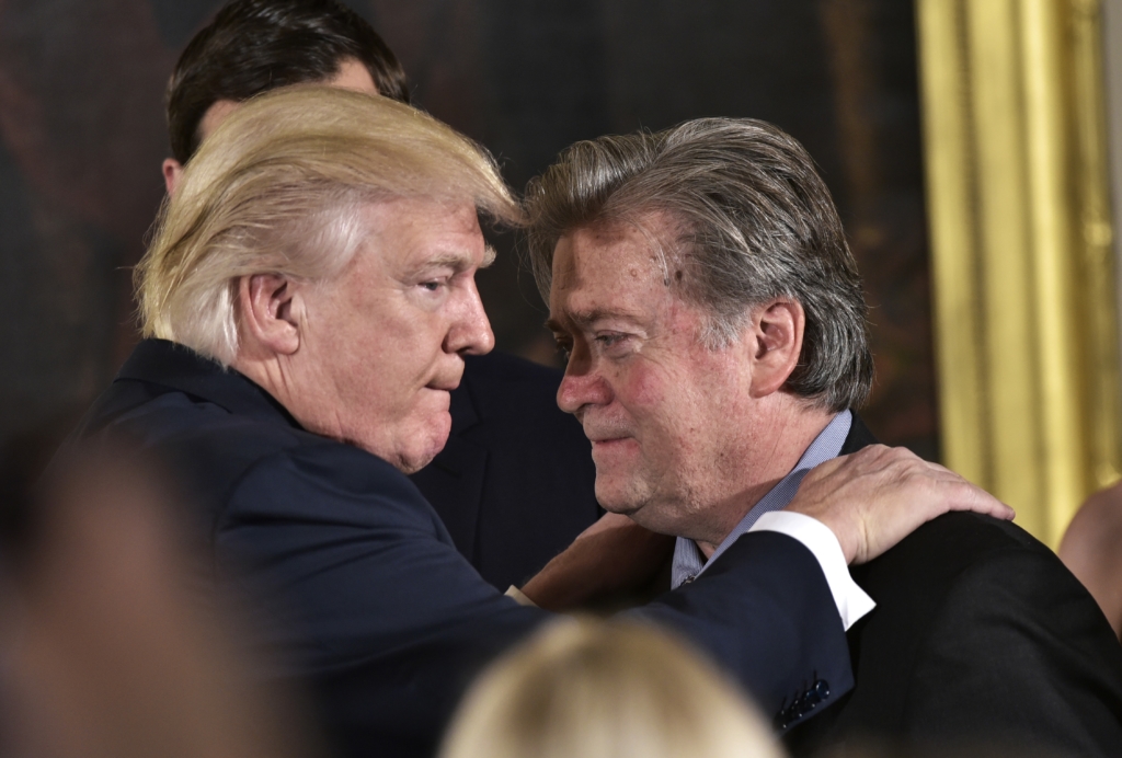 US President Donald Trump (L) congratulates Senior Counselor to the President Stephen Bannon during the swearing-in of senior staff in the East Room of the White House on January 22, 2017 in Washington, DC.
